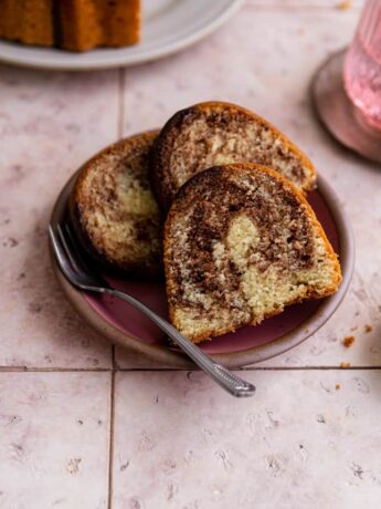Three slices of marble bundt cake on a pink plate.