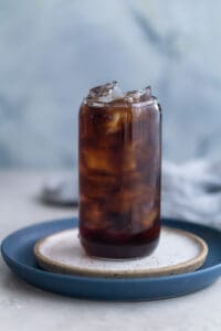 Cold brew added to ice in a glass cup.