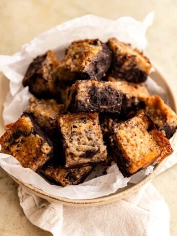 Banana Bread brownies layered onto a parchment lined plate.