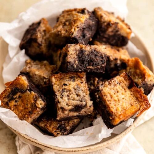 Banana Bread brownies layered onto a parchment lined plate.