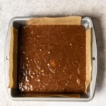 Banana brownie batter in a parchment lined brownie tin.
