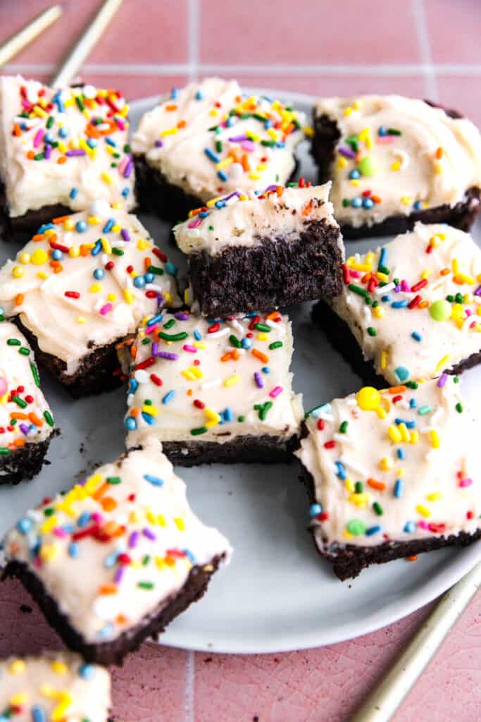Brownies frosted with vanilla frosting and rainbow sprinkles.