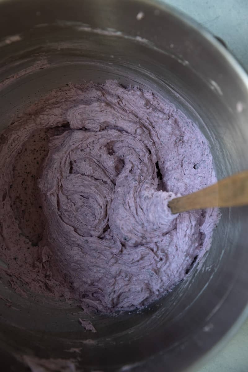 Blueberry frosting mixed in a bowl.
