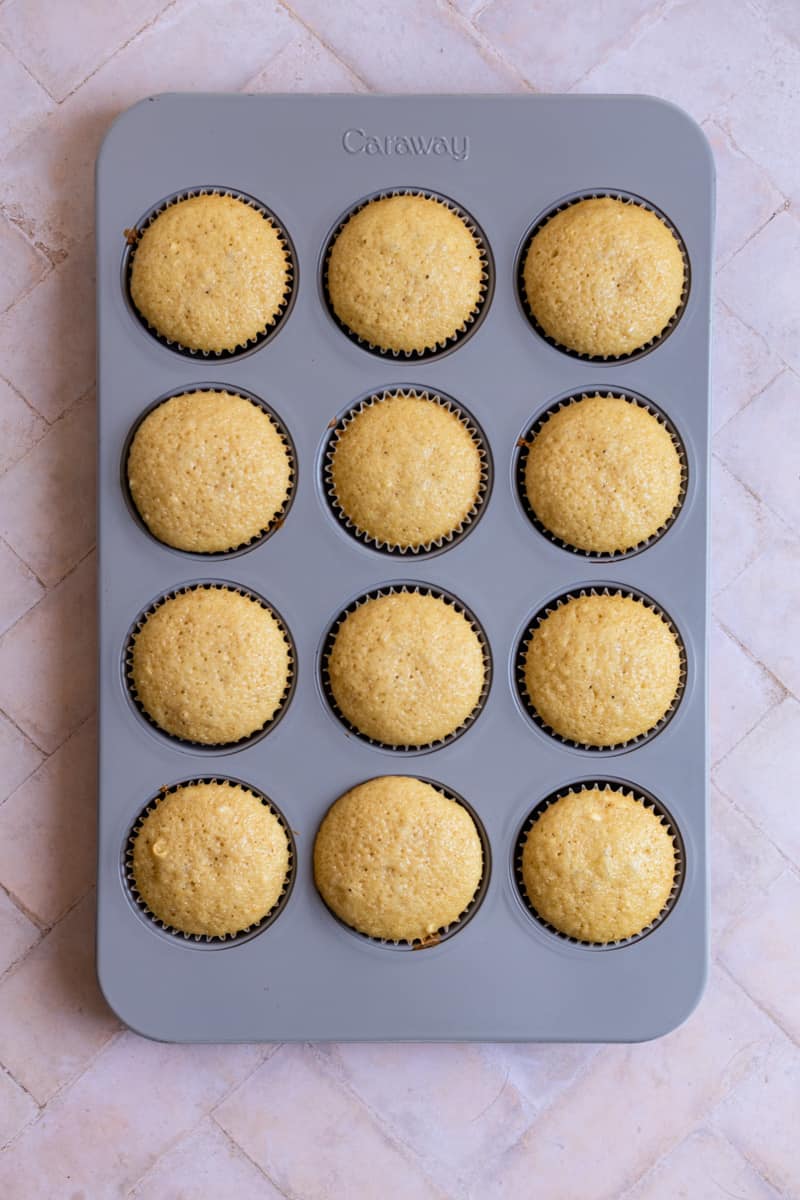 Vanilla cupcakes baked in a muffin tin.