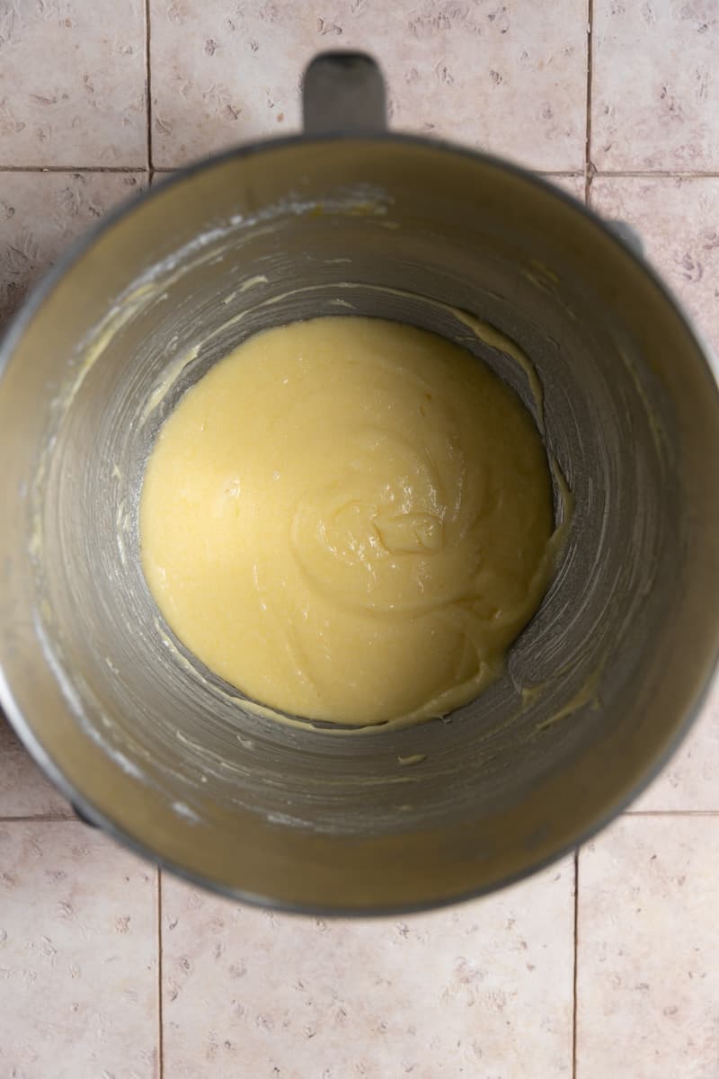 Butter, sugar, and eggs creamed in a mixing bowl.