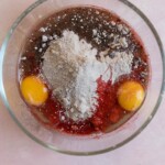 Red velvet cake mix, eggs, and oil in a glass bowl.