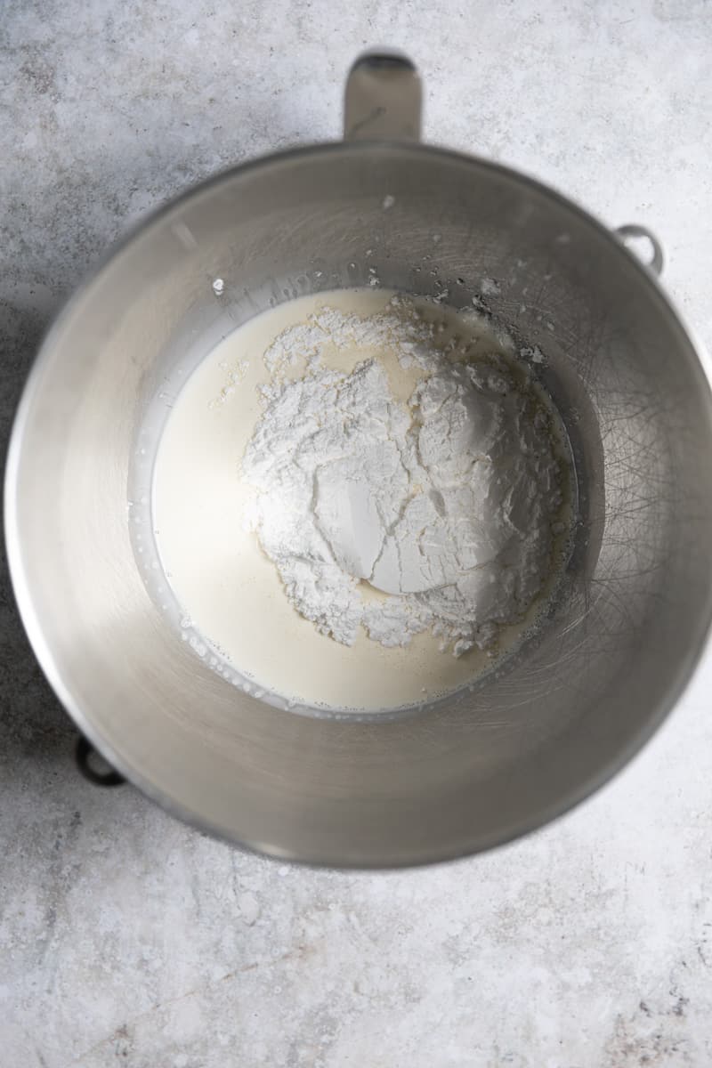 Heavy whipping cream and powdered sugar in a bowl.