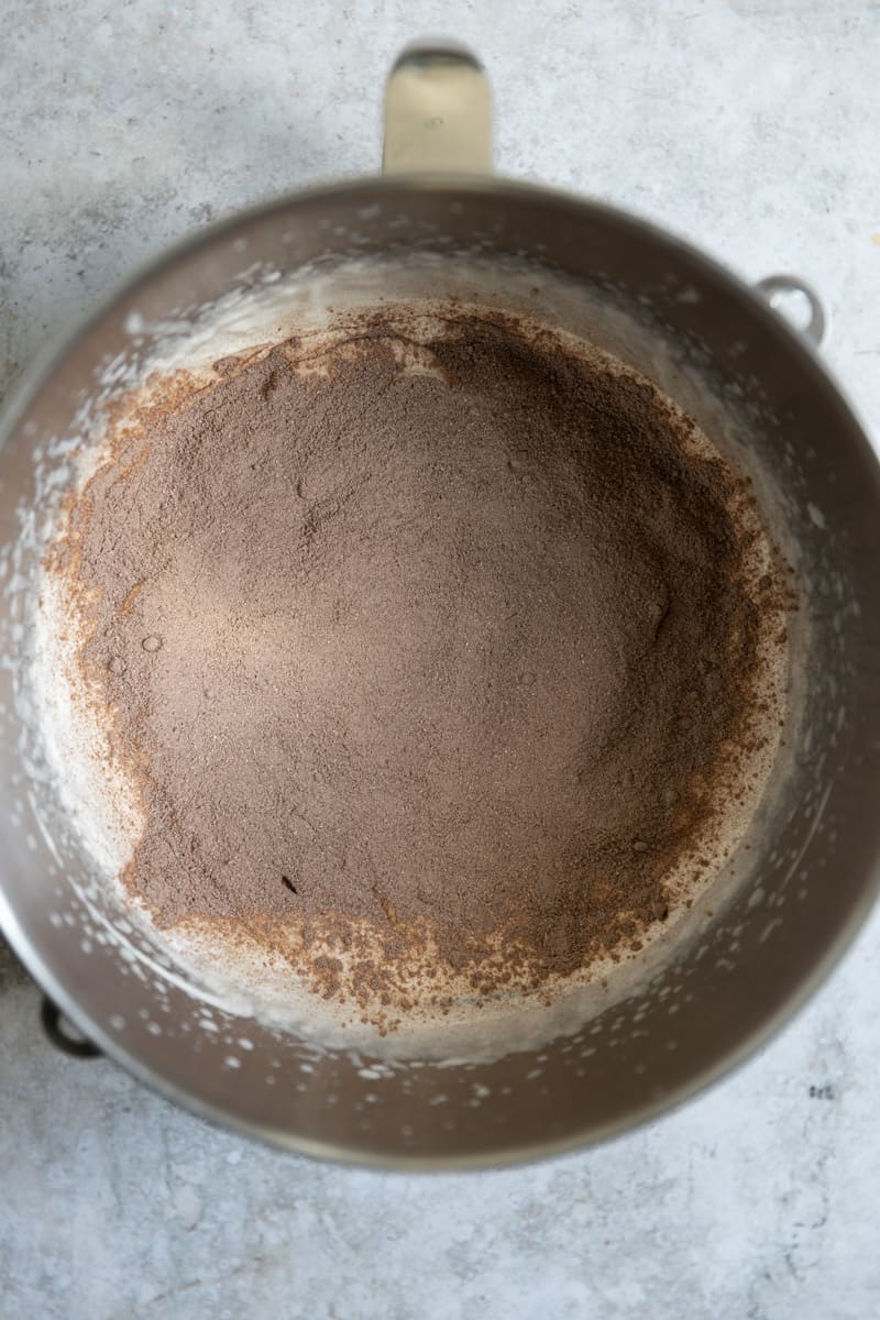 Chocolate pudding mix added to heavy cream in a bowl.