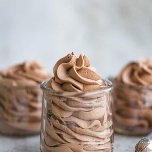 Whipped chocolate frosting in 3 small glass jars.