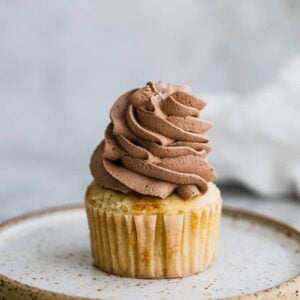 Whipped chocolate frosting piped onto a cupcake.