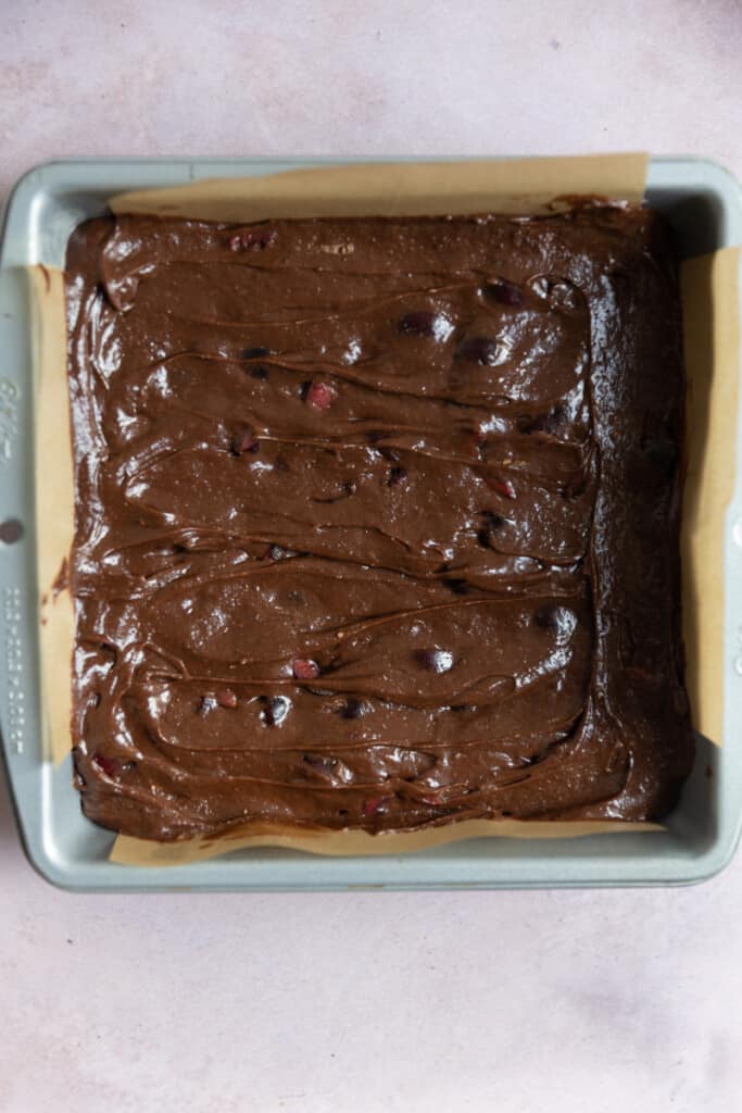 Black Forest brownies in an 8x8 pan lined with parchment paper.