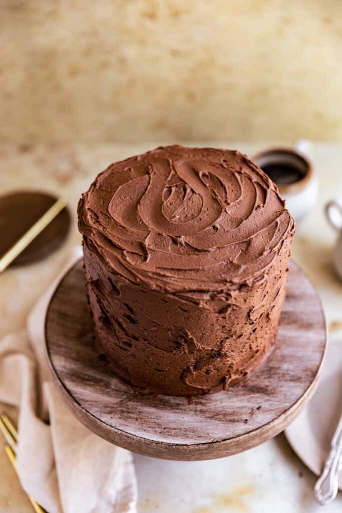 The top of a chocolate cake with the frosting swirled on a cake stand.