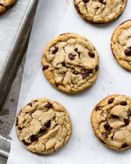 Perfectly round chocolate chip cookies next to each other on a tray.
