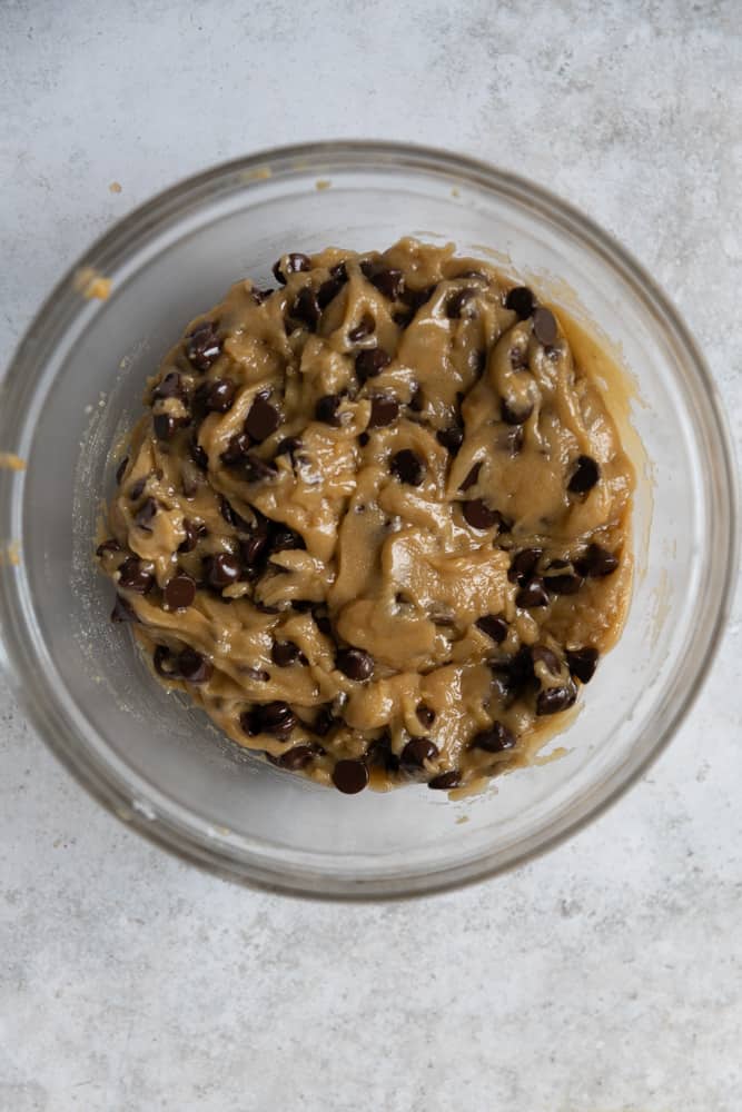 Chocolate chip cookie dough in a glass bowl.