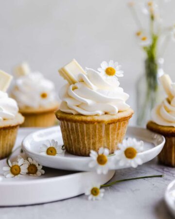 A vanilla cupcake decorated with white flowers.