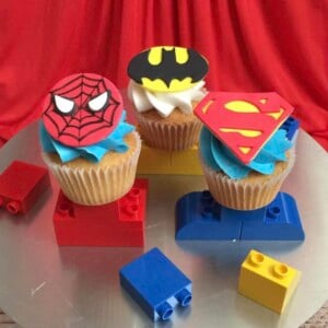Superhero themes cupcakes on a cake stand.