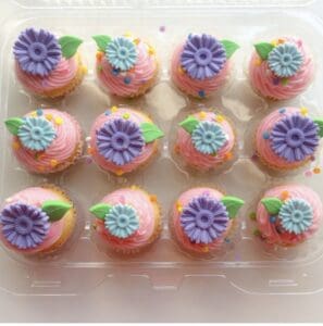 Mini cupcakes decorated with purple and blue fondant flowers.