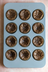 Baked brownie cupcakes in a muffin tin.