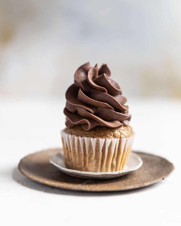 A cupcake topped with whipped chocolate ganache frosting.
