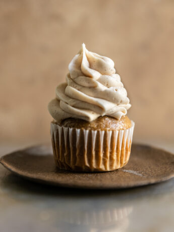 A cupcake frosted with cinnamon cream cheese frosting.