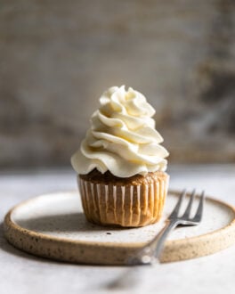 A cupcake with white frosting piped on top.