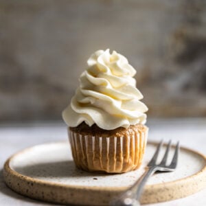 A cupcake with white frosting piped on top.