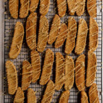 Gingerbread biscotti drizzled with brown sugar glaze on a wire rack.