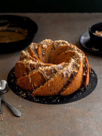 A bundt cake drizzled with glaze and streusel.