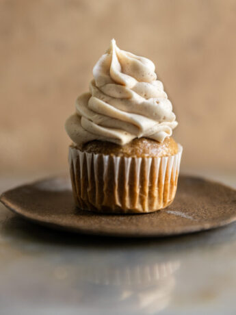 A cupcake frosted with cinnamon cream cheese frosting.