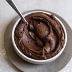 Fudge frosting in a bowl with a spoon sticking out.