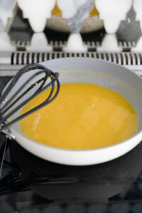 Lemon curd cooking on a stove top.