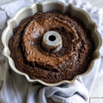 A baked brownie cake in a bundt pan with a linen underneath it.
