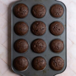 Baked chocolate cupcakes in a muffin tin.