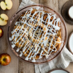 Cinnamon Roll Apple Pie in a pie dish on a wooden surface.
