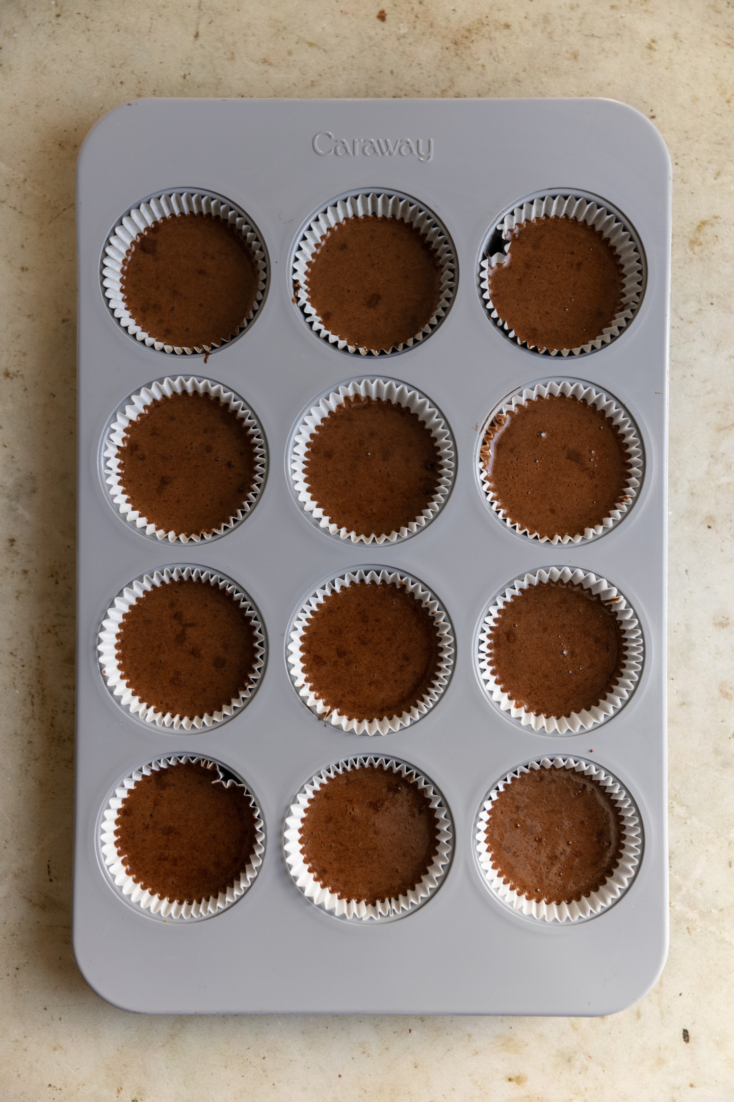 Nutella cupcake batter in a muffin tin.