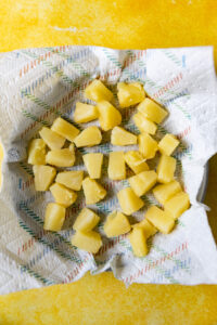 Pineapple chunks on a paper towel.