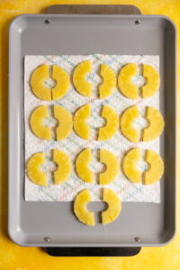 Pineapple slices drying on a sheet tray.