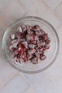 Raspberries dusted with flour in a bowl.