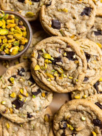 Pistachio chocolate chip cookies laid on top of each other.