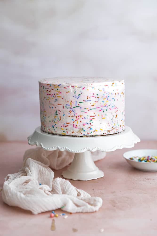 A cake frosted with funfetti frosting. 