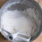 Butter, heat treated flour, and powdered sugar mixed together in a mixing bowl.