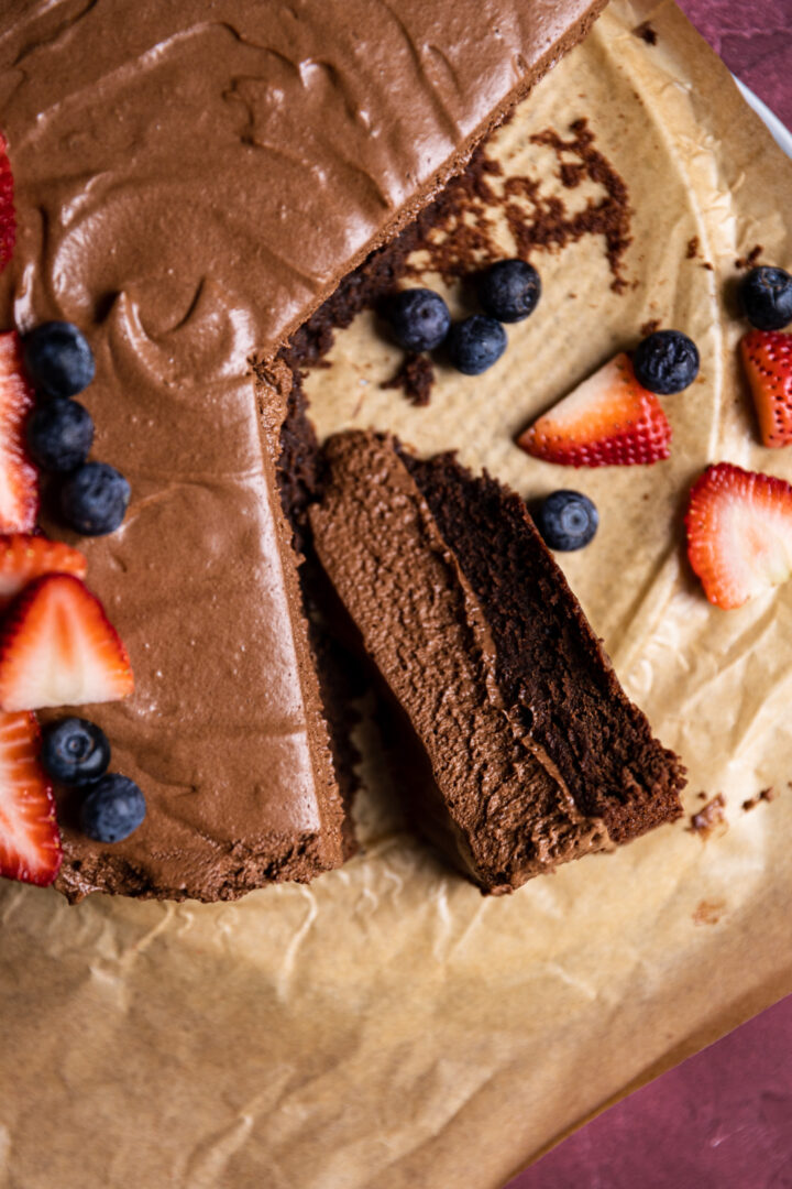 A slice of chocolate mousse cake on brown parchment paper.