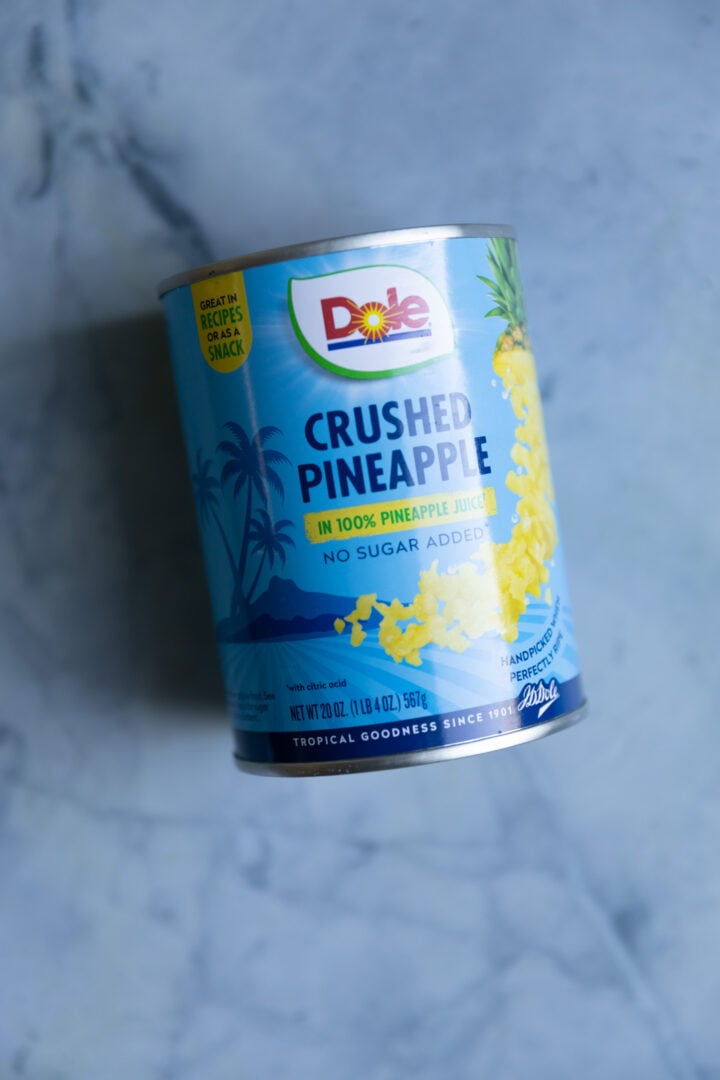 A can of crushed pineapple on blue surface.