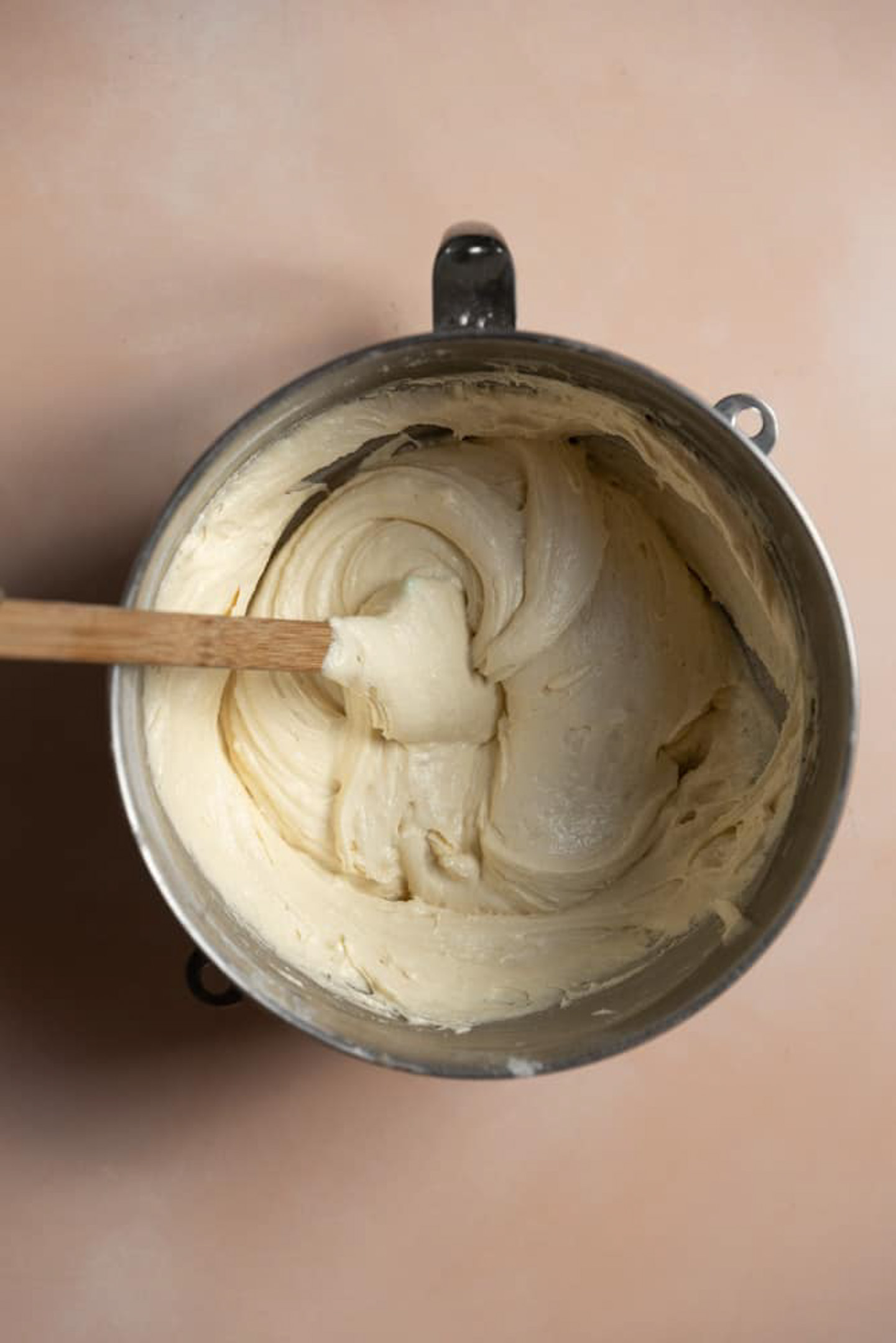 Yellow cake batter in a mixing bowl with a spatula in it.