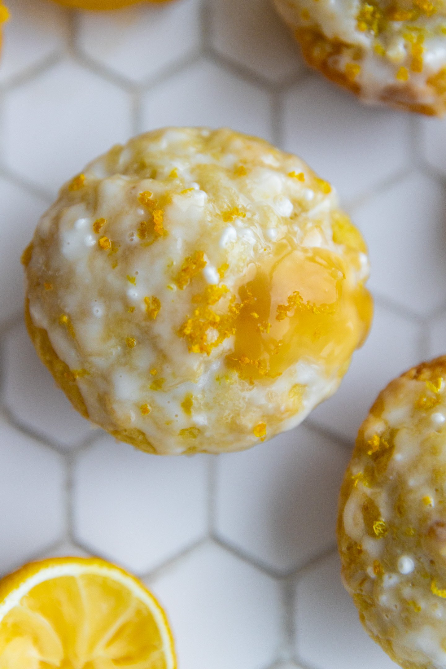 A lemon curd muffin on a white tiled backdrop.