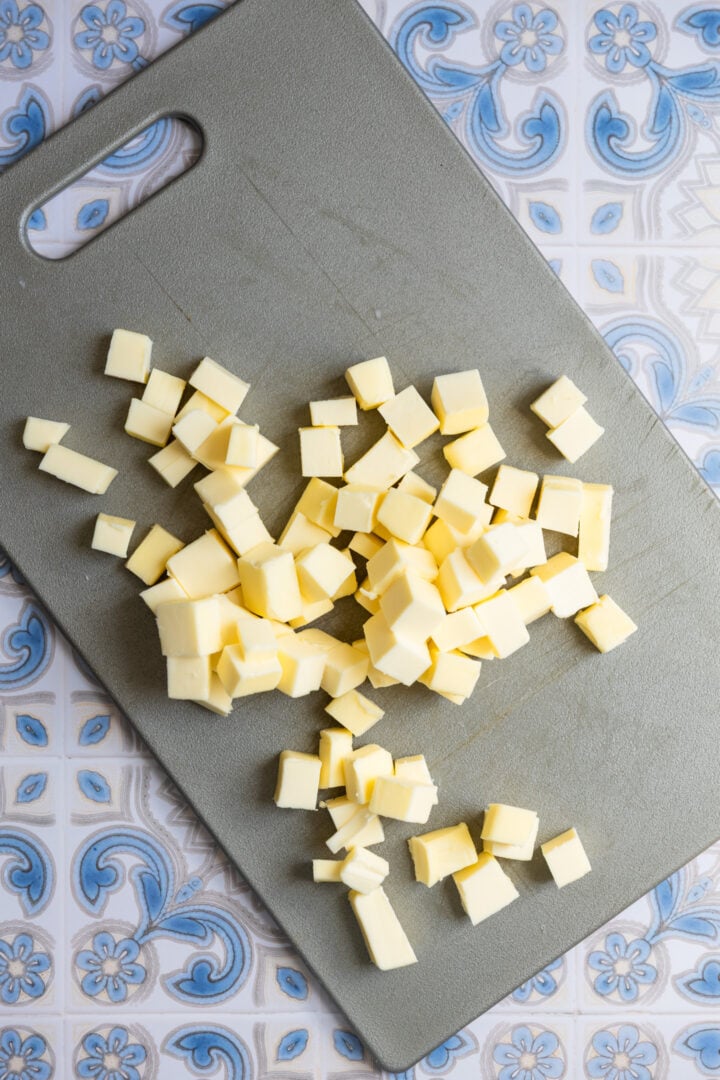Diced butter on a gray cutting board.