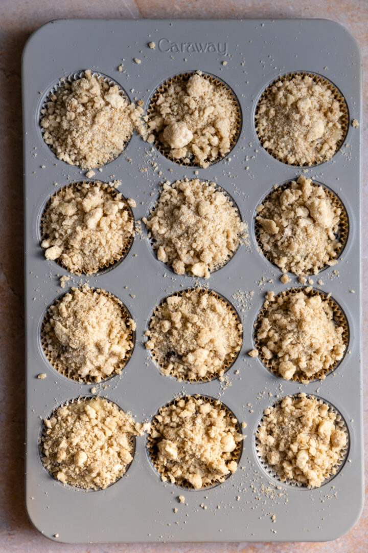Streusel topped muffin batter in a muffin tin,