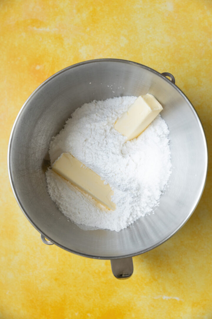 Powdered sugar and butter in a mixing bowl.
