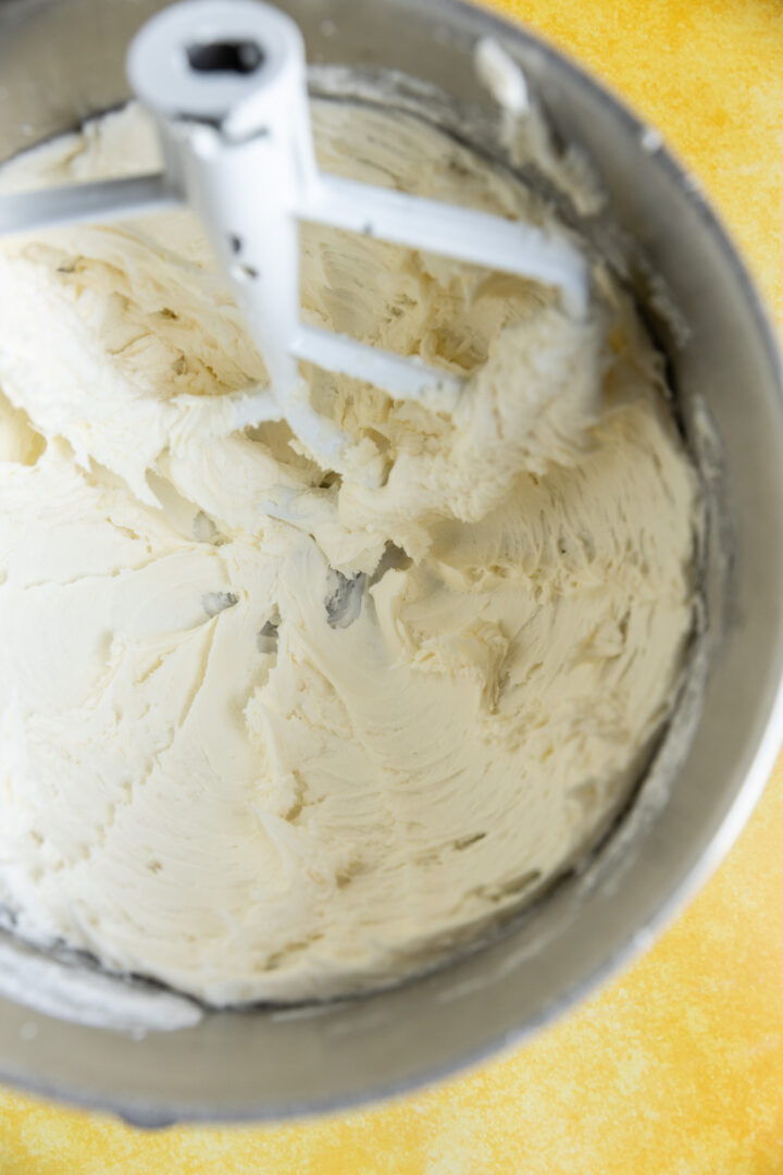 Whipped butter and powdered sugar in a mixing bowl.