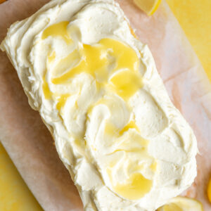 A loaf cake topped with lemon curd frosting.